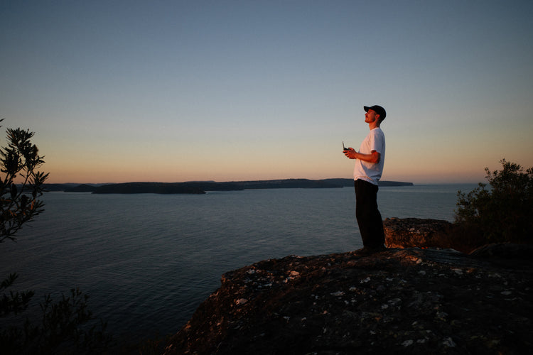 Harry on the edge of a cliff flying the Aeroo Pro drone